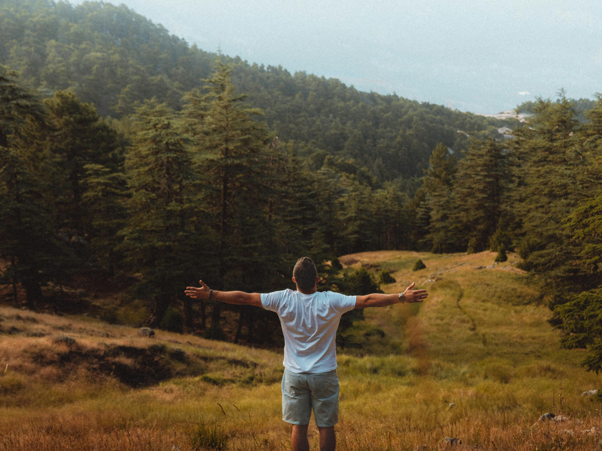Man with his arms outstretched in a beautiful mountain scene--loving nature